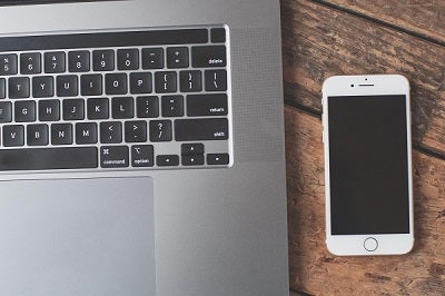 A laptop next to a cell phone