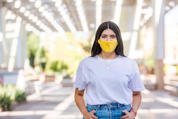 A woman in a mask in front of the Memorial Union