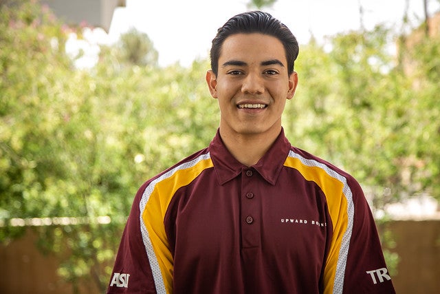 ASU student Oskar Fragozo poses in a maroon polo shirt