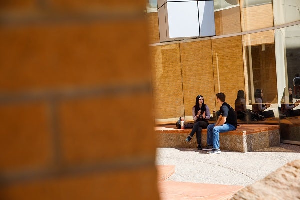 Two students talking and sitting