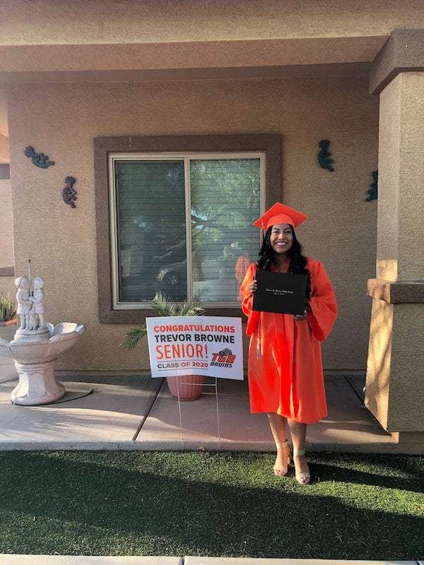 Itzel Itzel Aguilar Coconi stands tall in a cap and gown with her high school diploma. 