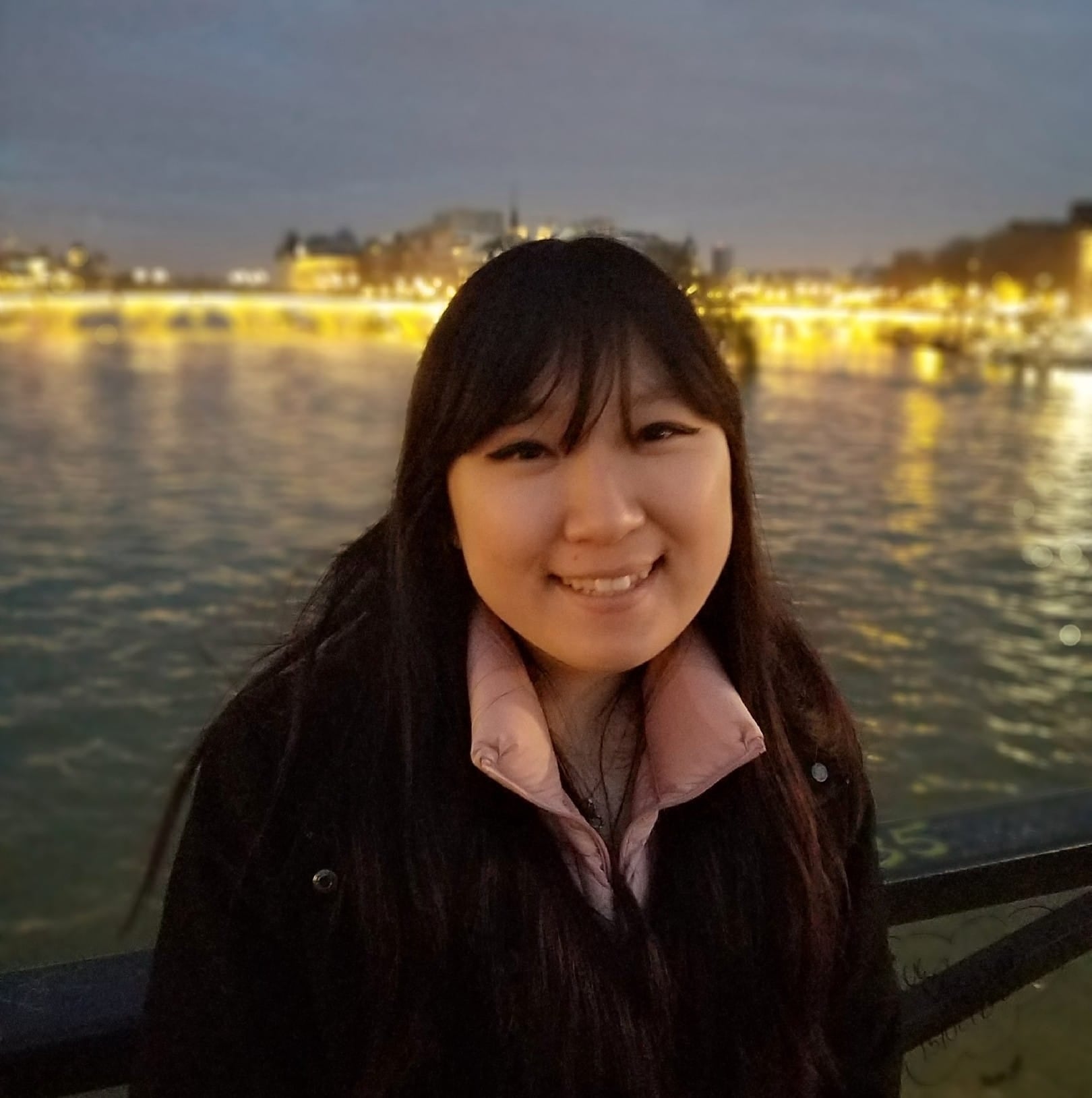 Sandy Chen flashes a smile in front of the water 